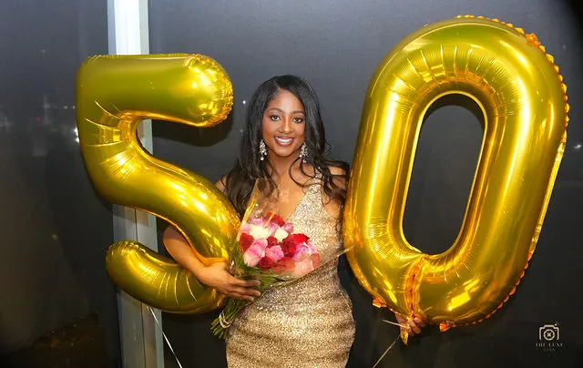 Fiftieth birthday portrait with gold balloons